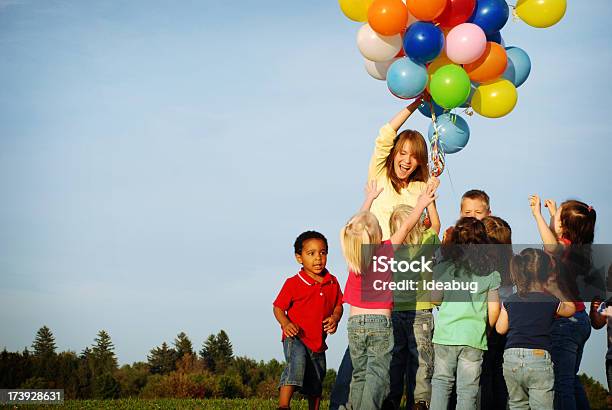 Une Los Niños Alcanzar De Globos Foto de stock y más banco de imágenes de Globo - Decoración - Globo - Decoración, Fiesta, Agarrar