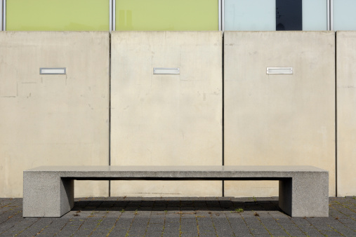 Modern concrete bench beside an office building.