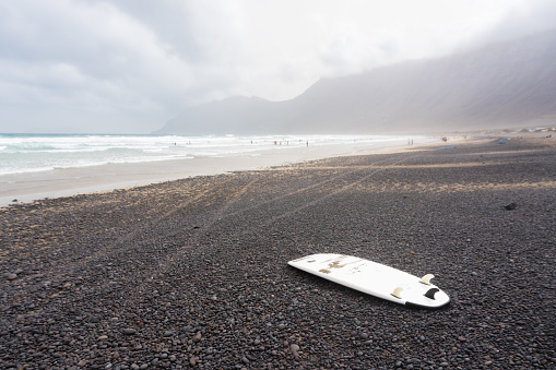 surfboard on the playa de Famara during a foggy day. This beach is famous among surfers