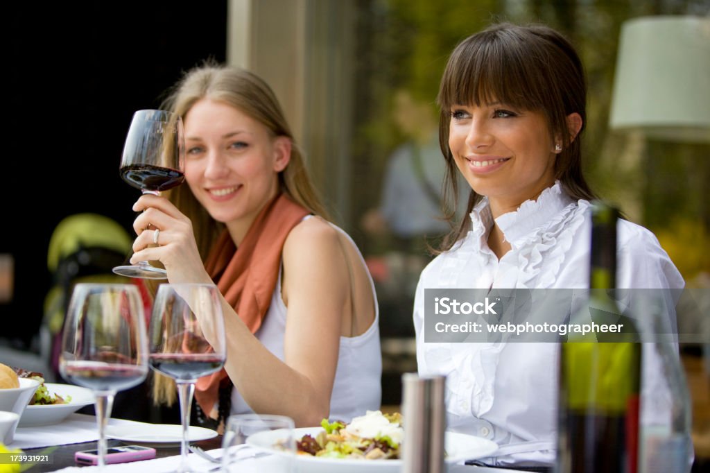 Gli amici al tavolo da pranzo - Foto stock royalty-free di Accanto