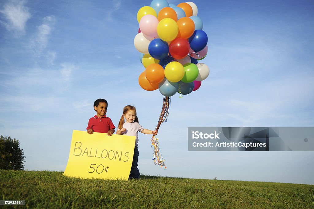 Kleine Jungen und Mädchen mit Luftballons im Verkauf - Lizenzfrei Geld verdienen Stock-Foto