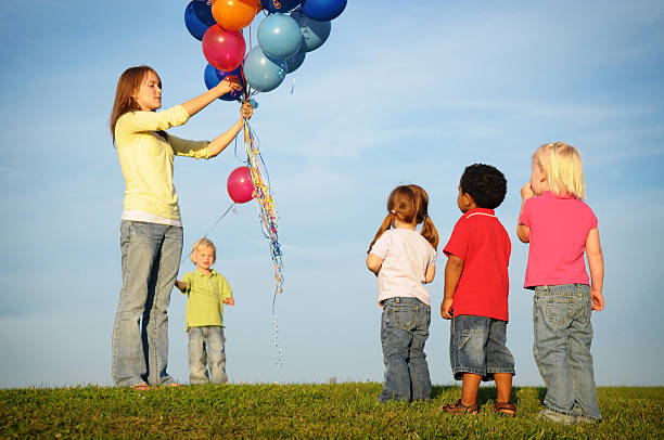 niños esperando en línea de un globo aerostático - child waiting in line in a row party fotografías e imágenes de stock