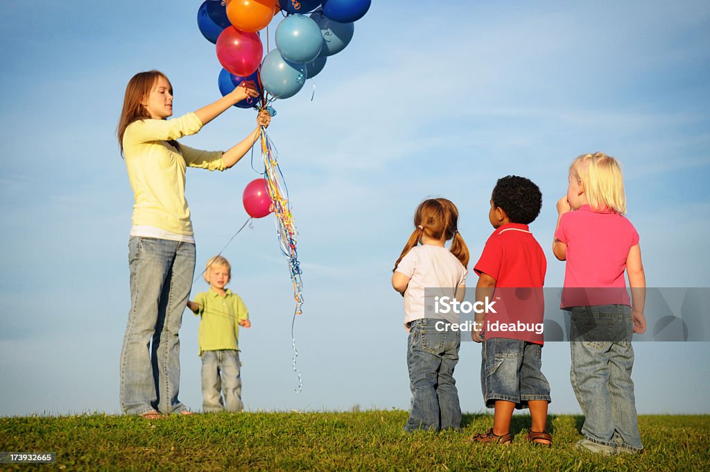 Bambini in attesa in linea per un palloncino - Foto stock royalty-free di 14-15 anni