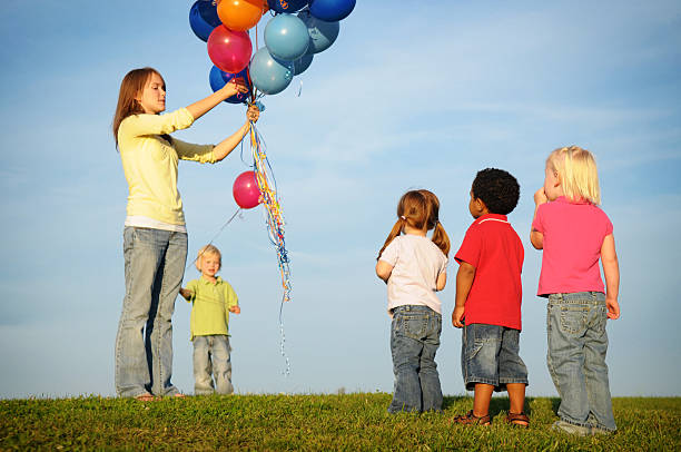 crianças a aguardar na fila para um balão - child waiting in line in a row party imagens e fotografias de stock