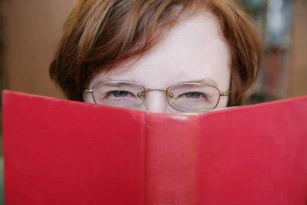 Scowling Teen Reading a Book
