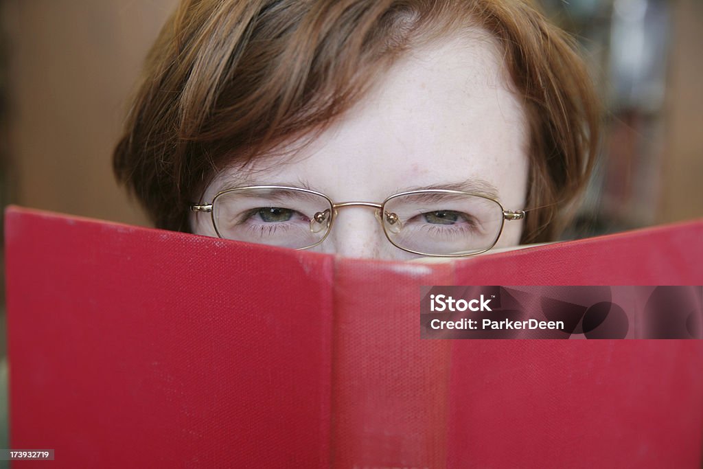 Scowling adolescente lendo um livro - Foto de stock de Apertar os Olhos royalty-free