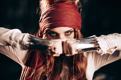Outdoor portrait of young female in pirate costume. Focus on eyes