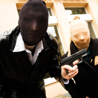 two Robbers in a stocking mask with gun 
