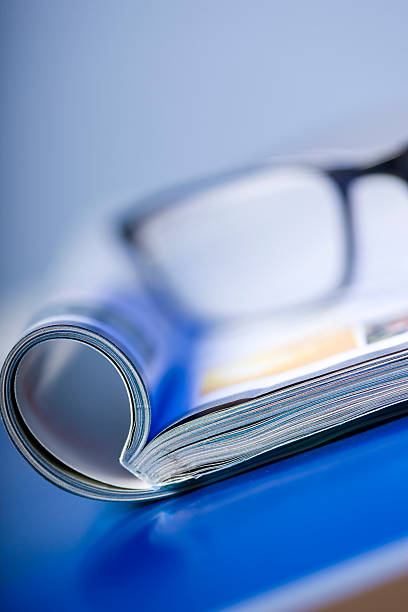Composition with glasses and open book on the table.