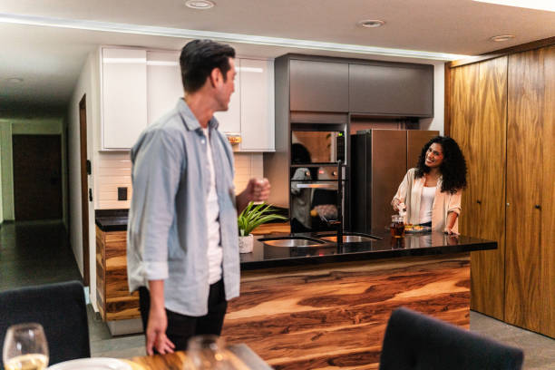 istock Couple talking while setting the dining table for a romantic date at home 1739343436