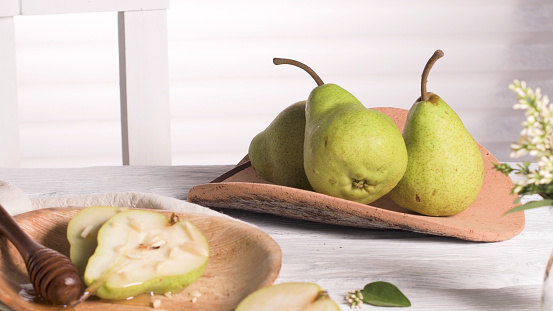 Tasty pears with honey and nuts on wooden table.