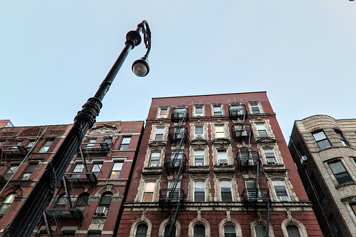 typical lower east side apartment building (tenement with fire escape, windows, lamp post) detail (red brick)