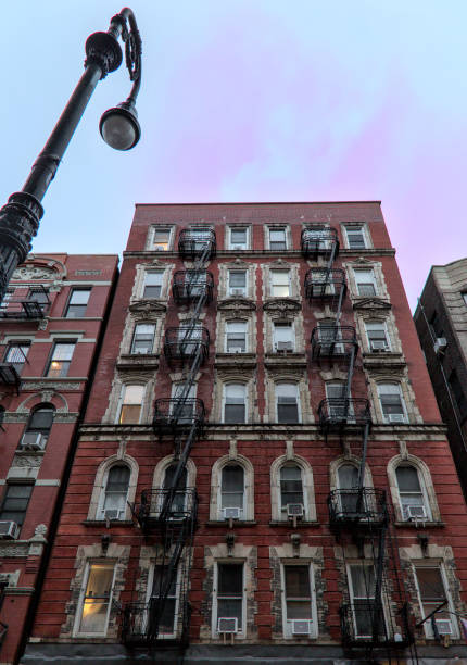 typical lower east side apartment building (tenement with fire escape, windows, lamp post) detail (red brick)
