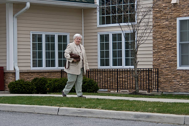 Senior woman leaving  residence stock photo