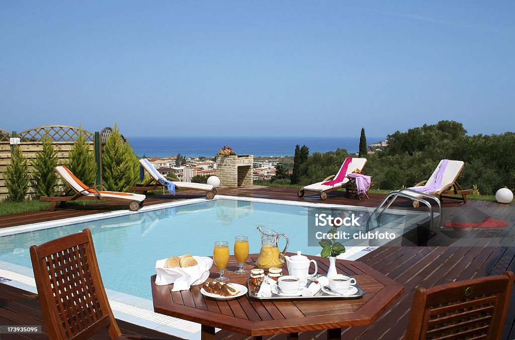 La prima colazione all'aperto nella piscina in una villa per le vacanze - Foto stock royalty-free di Algarve