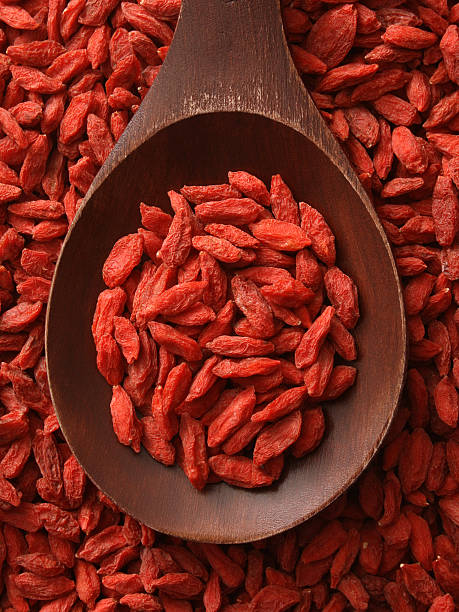 Top-view wooden spoon holding dried wolfberries
