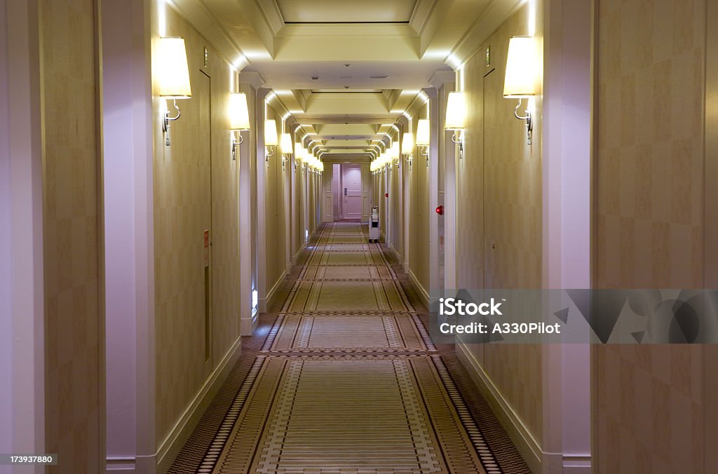 Hotel style, cream colored hallway with lamps Long hallway in a hotel. Corridor Stock Photo