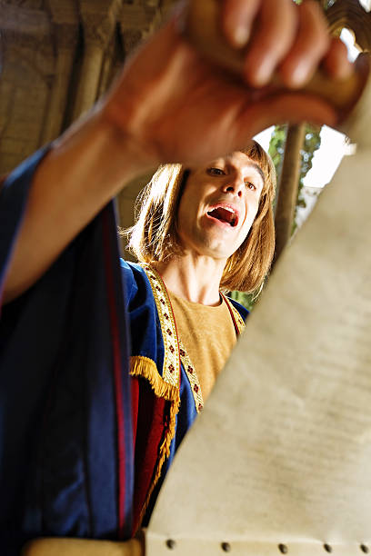 medieval poet medieval poet reading through a scroll in a medieval cathedral town criers stock pictures, royalty-free photos & images