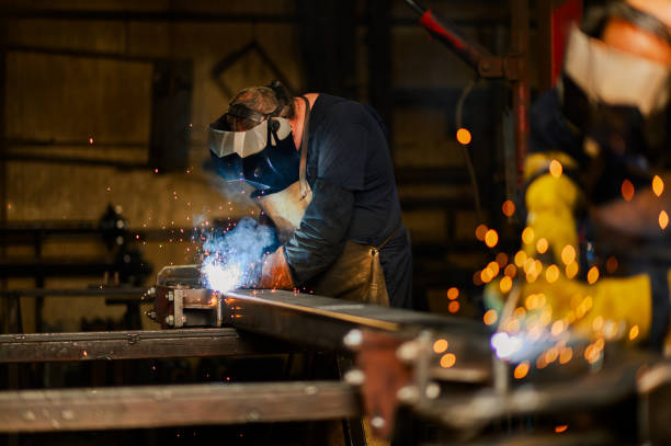 istock Worker with welding mask and safety gear welding a metal construction. 1739385092