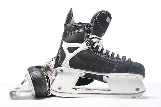 A pair of black and silver ice skates on a white background More ice hockey shots - check my lightbox. hockey skate stock pictures, royalty-free photos & images
