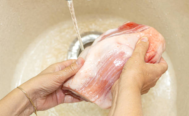 istock Female hands washing meat 1739387301