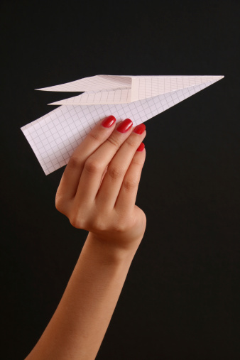 Woman hand holding paper airplane