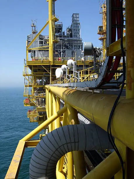 View along the side of offshore oil production platform showing microwave communication dishesMore offshore rig images:
