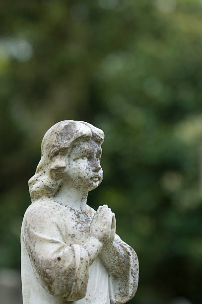 istock Statue on gravestone in cemetery 173938989