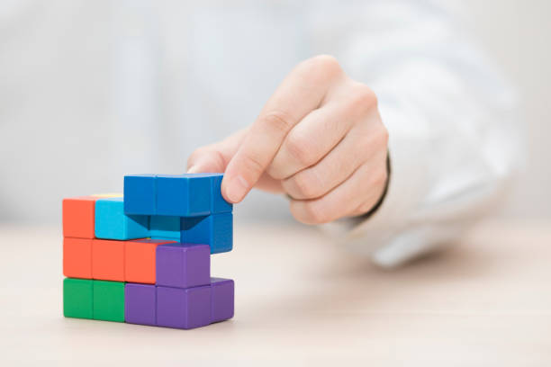 istock Man's hand stacking colorful wooden blocks. Business development concept 1739403022