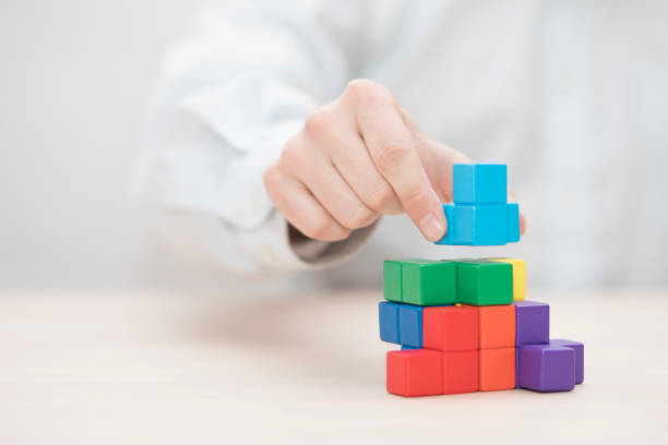 istock Man's hand stacking colorful wooden blocks. Business development concept 1739406920