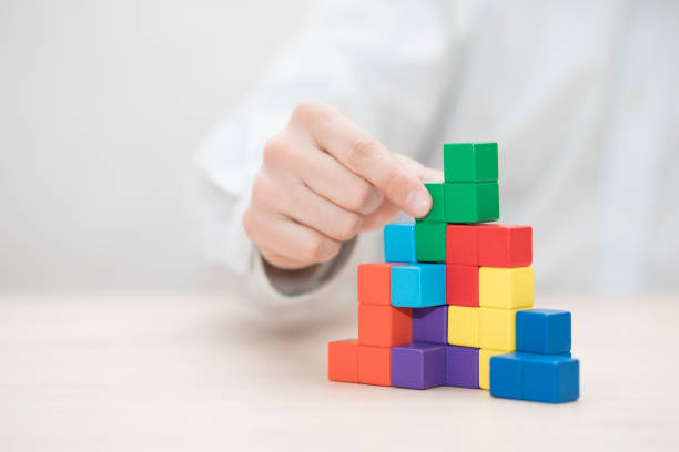 Man's hand stacking colorful wooden blocks. Business development concept