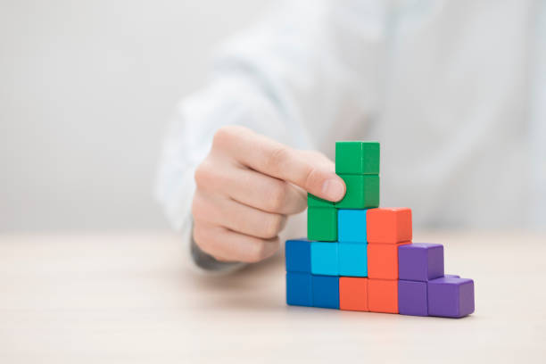 istock Man's hand stacking colorful wooden blocks. Business development concept 1739408090