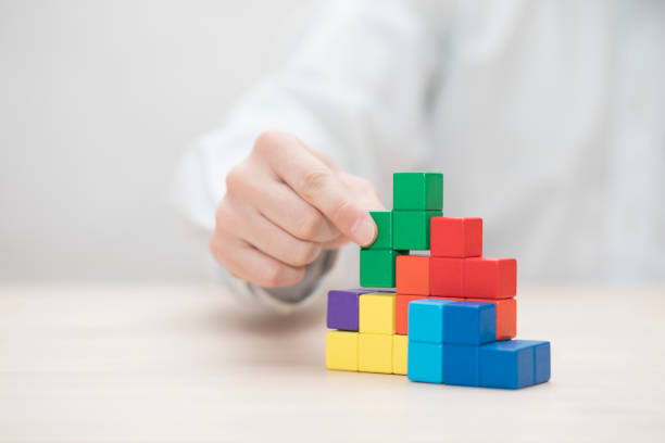 istock Man's hand stacking colorful wooden blocks. Business development concept 1739408693