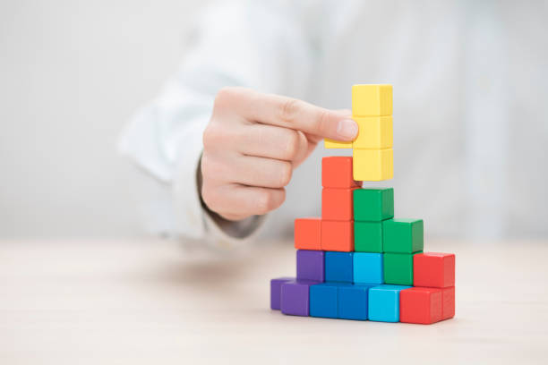 istock Man's hand stacking colorful wooden blocks. Business development concept 1739409884