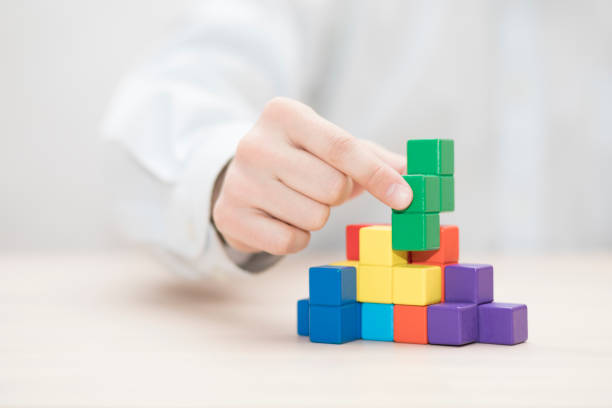 istock Man's hand stacking colorful wooden blocks. Business development concept 1739409894