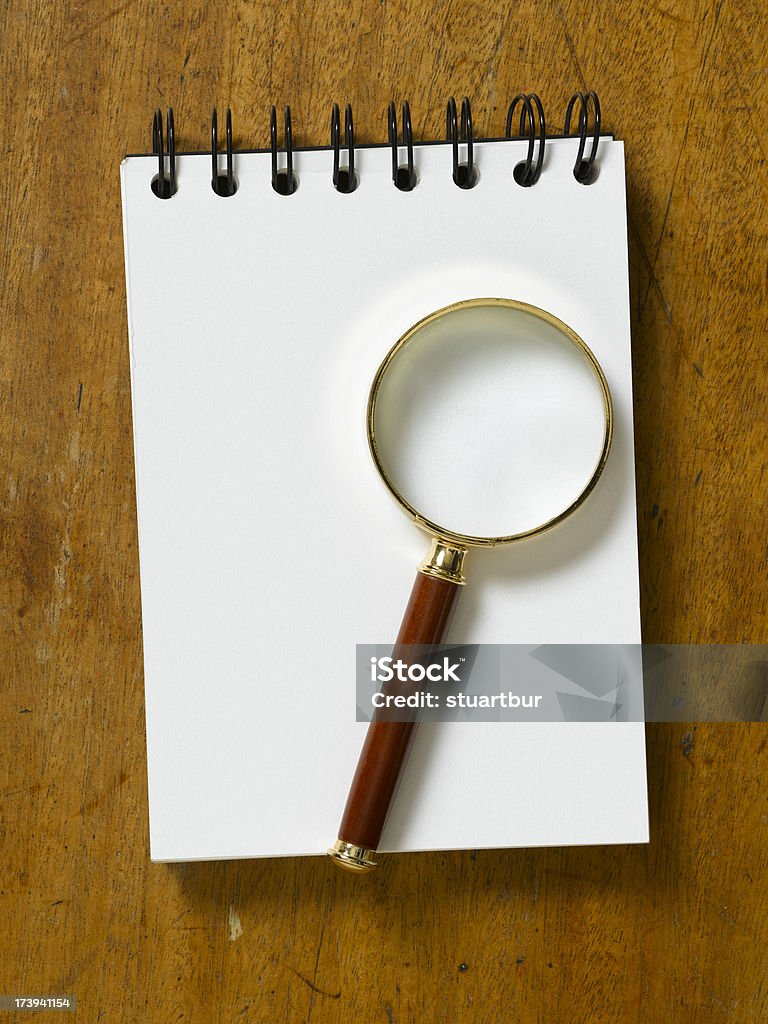 magnifying glass on table top old wooden table with gold magnifying glass on white paper Business Stock Photo