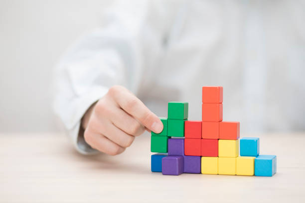 istock Man's hand stacking colorful wooden blocks. Business development concept 1739411574