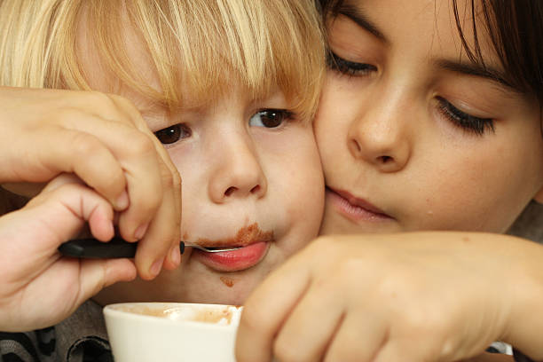helfende hand - child chocolate ice cream human mouth stock-fotos und bilder