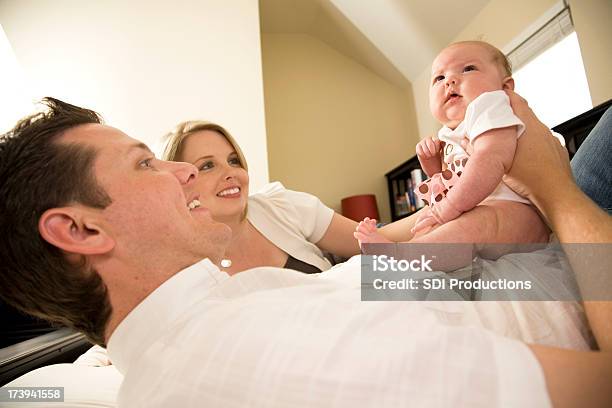 Happy Father And Mother Playing With Their Baby Girl Stock Photo - Download Image Now