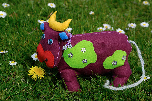 Homemade felt cow on grass