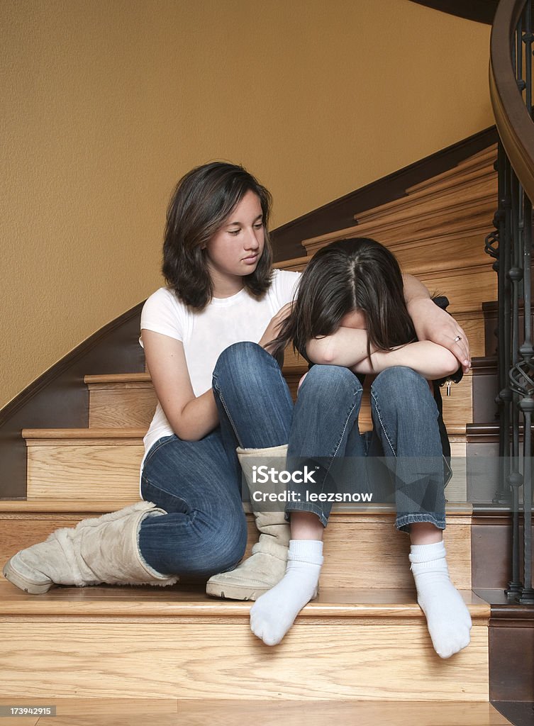 Girl Consoling Her Sister Young girl consoling a sad little friend on the stairs.Click on the image below to view other shots of these models as well as other kids and families: Consoling Stock Photo