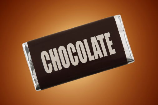 Bar of chocolate on cocoa brown background.More fake products: