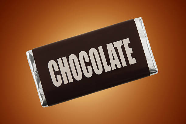 Chocolate Bar Bar of chocolate on cocoa brown background.More fake products: chocolate bar stock pictures, royalty-free photos & images