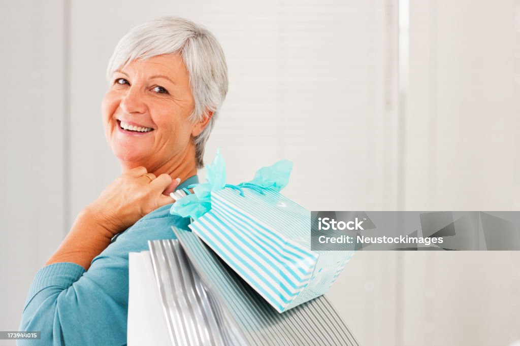 Senior mujer sosteniendo bolsas de la compra - Foto de stock de 60-64 años libre de derechos