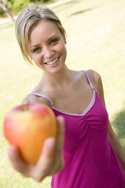 istock Focus on Pretty Woman Holding Out Her Apple 173944282