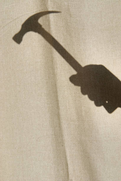 istock Hand with a hammer behind the curtain 173945446