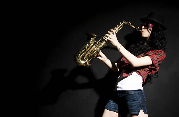 Saxophone with Musician Female musician is playing a saxophone. big band jazz stock pictures, royalty-free photos & images