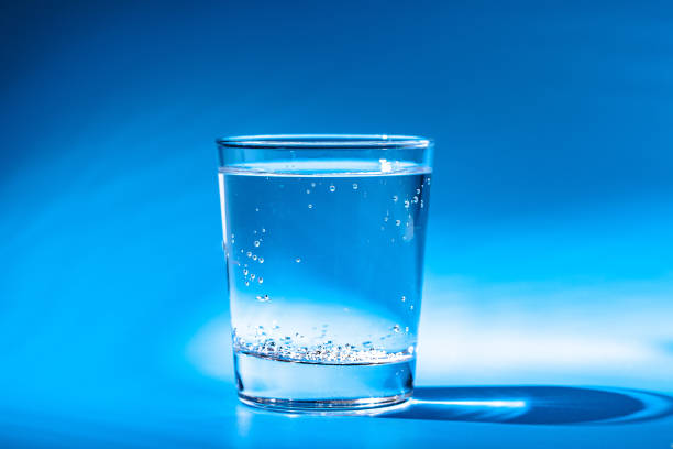istock A glass with water drops on a dark blue background close up 1739467913