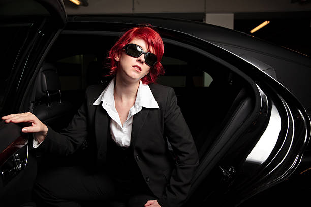 mafia chick getting out of the car pretty mafia chick getting out of the car, wearing huge sunglasses celebrity limo stock pictures, royalty-free photos & images