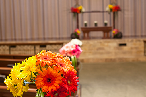 Gerber daisy alter flowers and pew flowers in oriental style for a wedding.